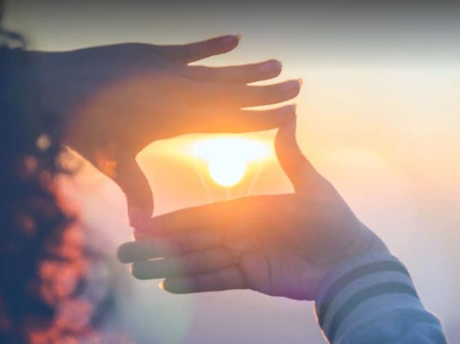 shiny-ball-syndrome-blog-person-making-frame-with-fingers-highlighting-sun-during-sunset-thinking-without-restrictions-2023-1920×549 Person making a rectangle around the sunset with their hands
